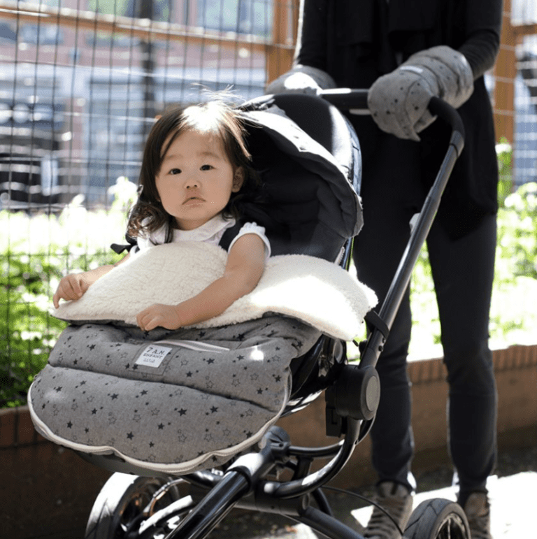 niña dentro de saco de paseo