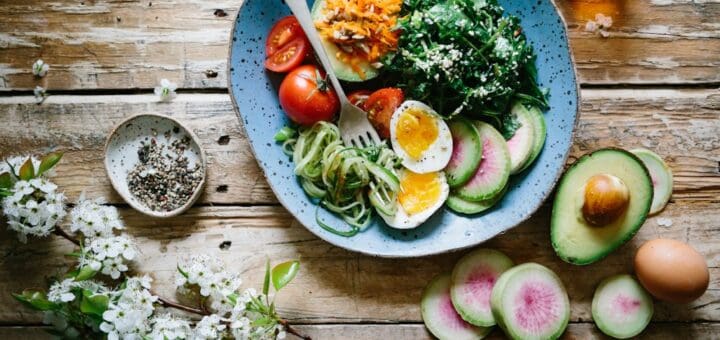 poached egg with vegetables and tomatoes on blue plate