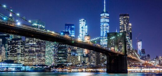 Stunning view of the Brooklyn Bridge and New York City skyline illuminated at night.